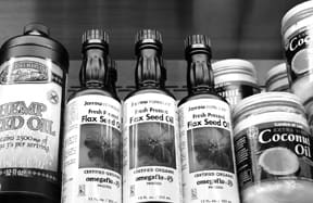 a variety of edible oils on a shelf at a health food store