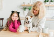 Grandmother With Granddaughter Sitting With Dog