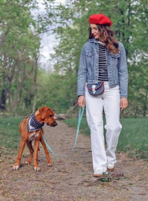 Female owner with Rhodesian Ridgeback puppy in nature