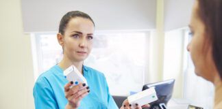 Female veterinarian giving medication to dog owner in veterinary surgery