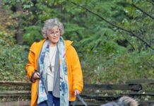 Woman taking her dog for a walk on a forest path