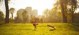 Young women playing with her dog A golden retriever runs towards it's female owner during playtime in the park.