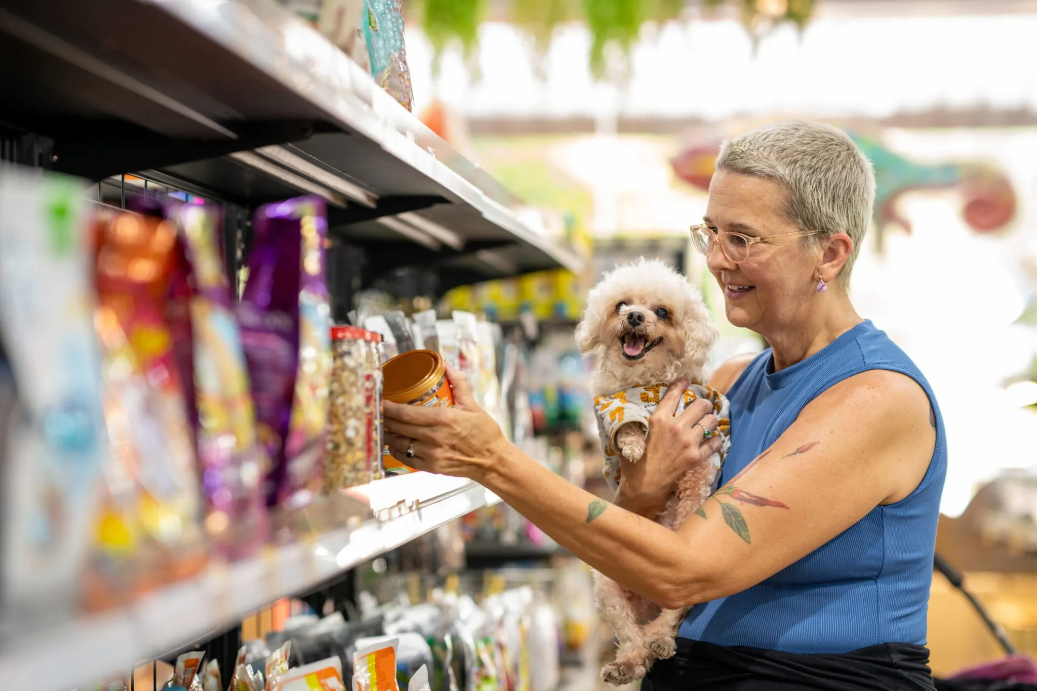 Tutor examinando atentamente o rótulo de um produto para cães, verificando os ingredientes.